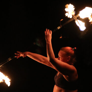 Deb Striker spinning a fire dragon staff